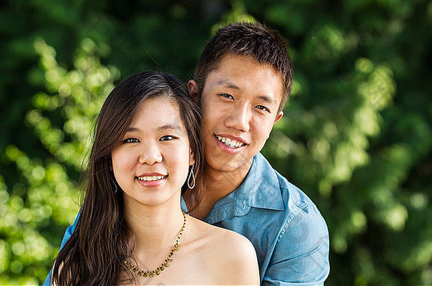 水平照片年轻的夫妇持有向前绿色树背景