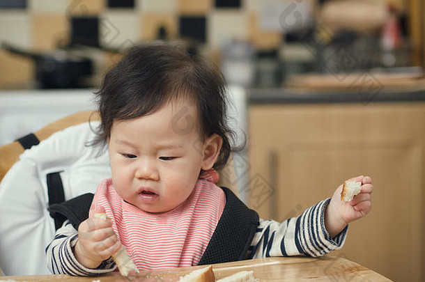 亚洲婴儿女孩吃面包时间