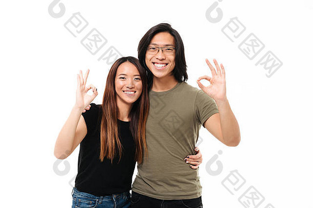 快乐的亚洲夫妇显示手势拥抱相机孤立的白色背景