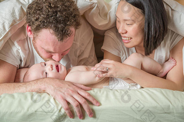 混合比赛中国人高加索人婴儿男孩铺设床上父亲妈妈。