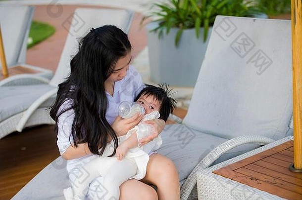 年轻的快乐可爱的亚洲中国人女人玩女儿婴儿女孩假期热带度假胜地游泳池享受夏天假期旅行