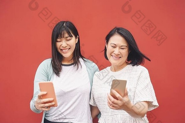 亚洲妈妈。女儿移动智能<strong>手机</strong>户外快乐中国人家庭有趣的技术时尚的社会媒体应用程序