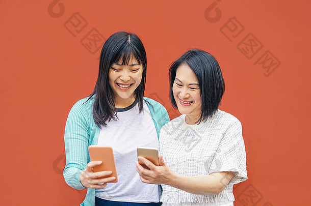 亚洲妈妈。女儿移动智能<strong>手机</strong>户外快乐中国人家庭有趣的趋势技术应用程序社会媒体