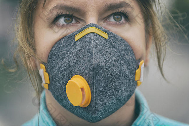 女人穿真正的反污染的anti-smog病毒脸面具密集的烟雾空气