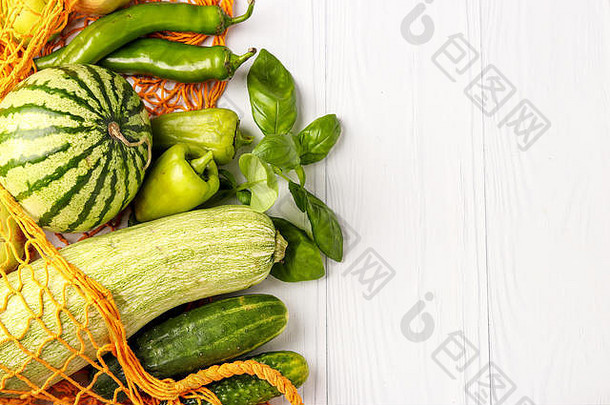 绿色蔬菜水果橙色可重用的购物网袋白色背景西葫芦黄瓜贝尔胡椒热辣椒苹果梨什么