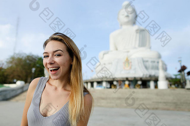 年轻的漂亮的女孩站佛雕像普吉岛泰国