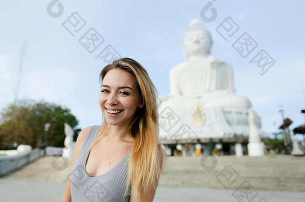 年轻的金发女郎女孩站佛雕像普吉岛泰国