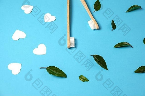 浪费概念木竹子生态友好的牙刷绿色叶白色心蓝色的背景生态友好的情人节一天概念