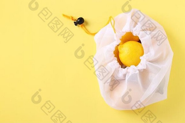 柠檬可重用的生态友好的网袋明亮的黄色的背景浪费概念停止污染复制空间
