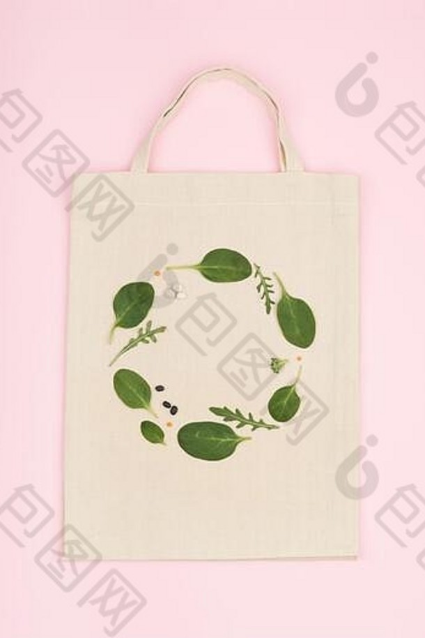 帆布生态袋有创意的绿色作文使绿色菠菜叶rucola豆平躺视图粉红色的背景