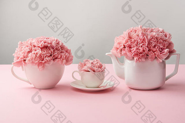 白色杯水壶美丽的粉红色的花灰色