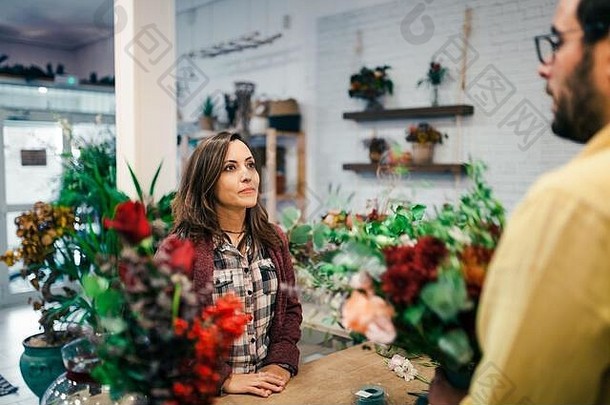 年轻的女人购买花束花花店
