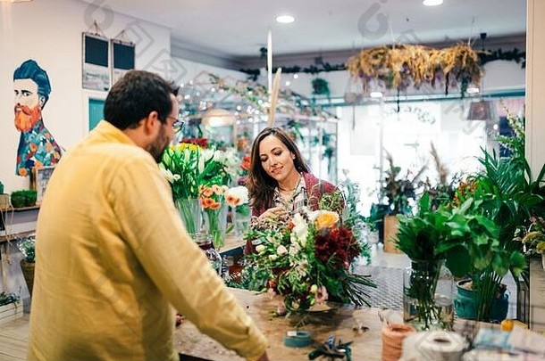 年轻的女人购买花束花花店