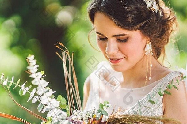 美丽的新娘花束花站森林背景乡村风格美丽的新娘精致的衣服在户外关闭肖像年轻的