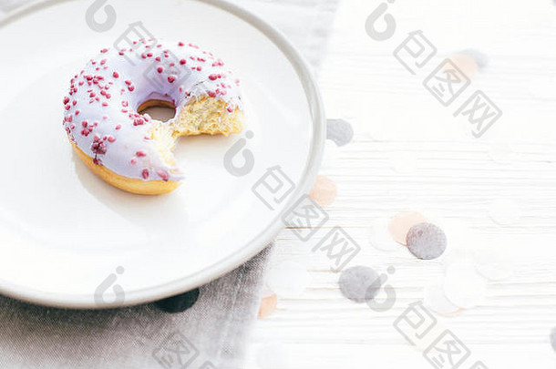 美味的咬甜甜圈洒时尚的板白色表格五彩纸屑聚会，派对概念饮食糖果酒吧婚礼接待紫色的