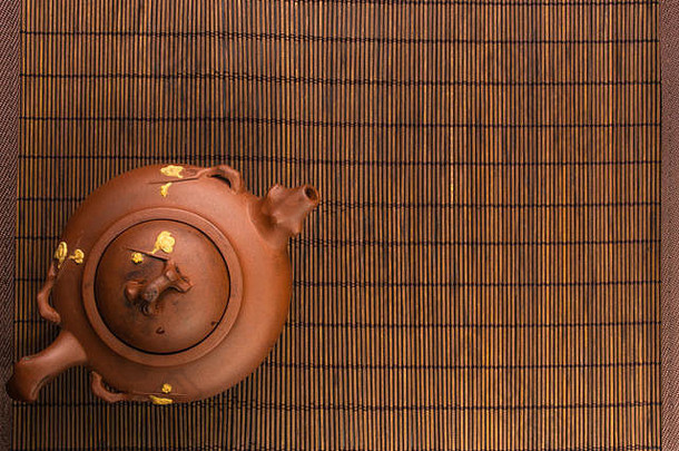 棕色（的）中国人茶壶宜兴粘土传统的点缀竹子席