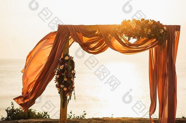 广场木婚礼拱户外日落婚礼仪式红色的玫瑰花挂布令人惊异的温暖的太阳光
