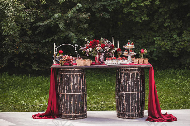 婚礼接待木表格站桶装饰红色的花糖果饮料丝绸乡村风格