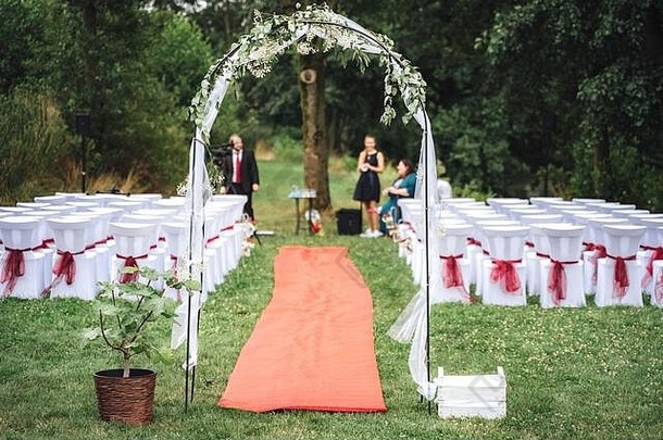 婚礼装饰拱地毯装饰椅子草坪上公园户外婚礼婚礼一天概念