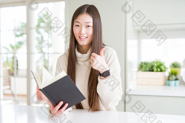 美丽的亚洲女人阅读书快乐大微笑标志拇指<strong>手指</strong>优秀的标志