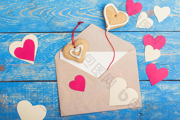 信封手工制作的纸心心形状饼干乡村木蓝色的表格情人节一天问候卡前视图