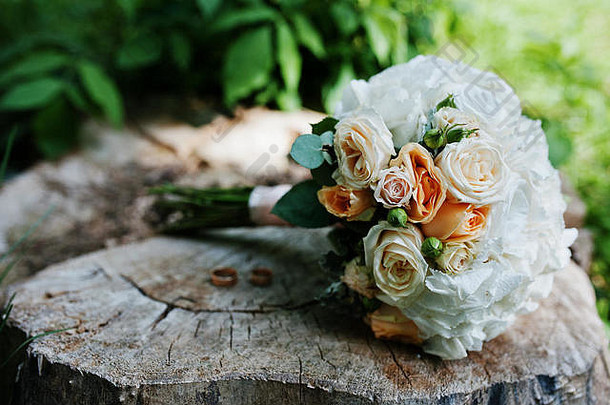 温柔婚礼花束粉红色的橙色白色玫瑰婚礼环树桩木