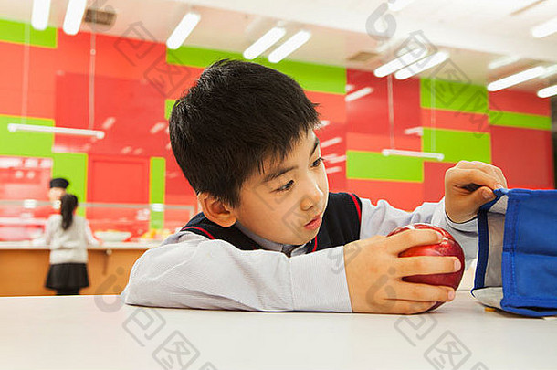 学校男孩检查午餐袋学校自助餐厅