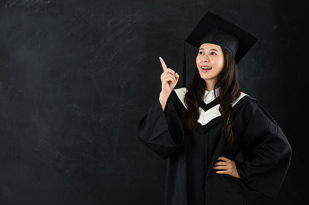 微笑亚洲女孩指出空气黑板上手腰好的想法Copyspace肖像研究生学生图片概念