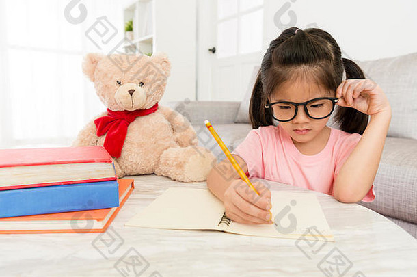 年轻的女孩孩子学生研究英语知识首页写作家庭作业假期泰迪熊玩具