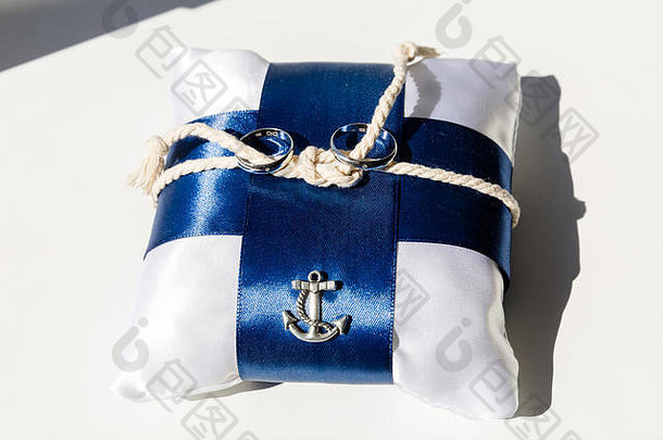一对婚礼环白色枕头蓝色的丝带中间枕头绳子系海结一边枕头金属装饰形状海锚