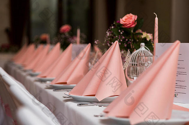 婚礼表格白色桌布椅子粉红色的餐巾盘子菜