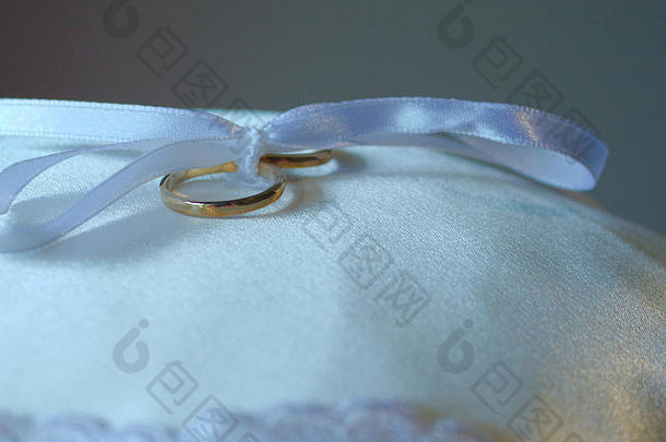 白色丝带系弓持有婚礼环枕头