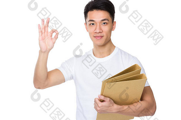 亚洲年轻的男人。持有文件夹标志手势