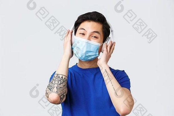 情绪生活方式休闲冠状病毒科维德概念英俊的年轻的无忧无虑的朝鲜文的家伙医疗面具耳机