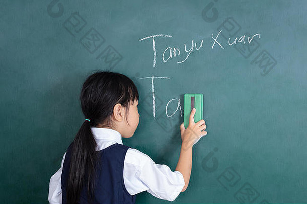亚洲中国人女孩擦拭绿色黑板上教室