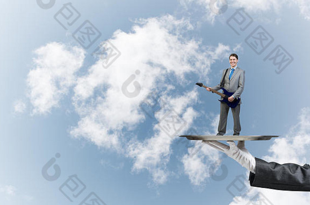 商人金属托盘玩电吉他蓝色的天空背景