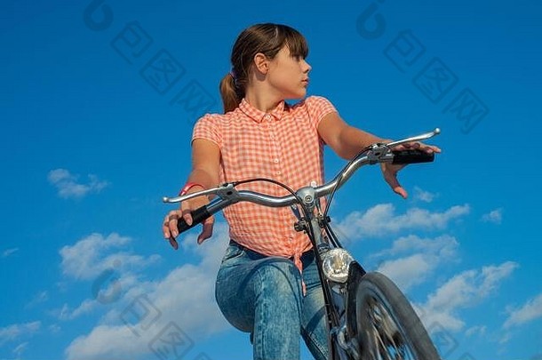 女孩驱动器自行车蓝色的天空背景