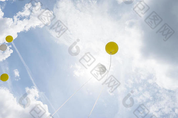 白色黄色的氦气球覆盖太阳绳子多云的天空背景