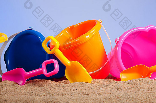 行色彩斑斓的海滩桶水桶铲子桑迪海滩蓝色的天空背景复制空间