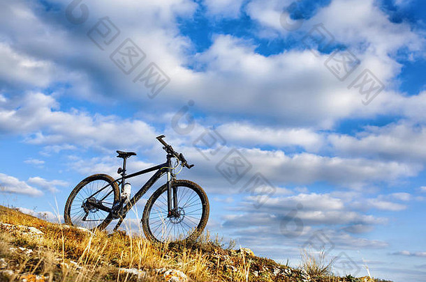 黑色的自行车山蓝色的天空背景