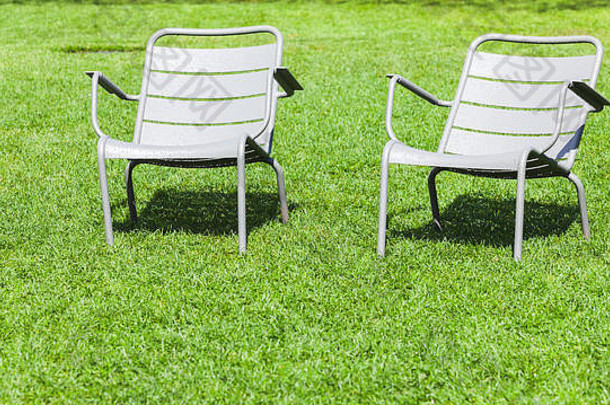 户外金属椅子站新鲜的绿色草夏天公园