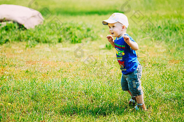 快乐男孩孩子运行夏天绿色草草地公园阳光明媚的一天户外