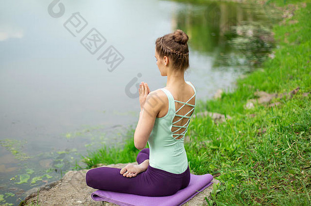 纤细的高加索人浅黑肤色的女人女孩瑜伽夏天绿色草坪上河
