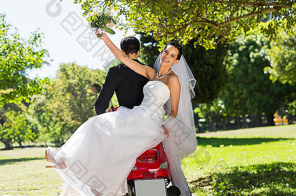 新婚夫妇坐着踏板车公园