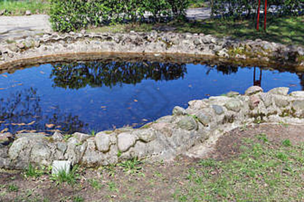 人工手工制作的小池塘春天木海岸湖使花岗岩石头阳光明媚的一天户外图像