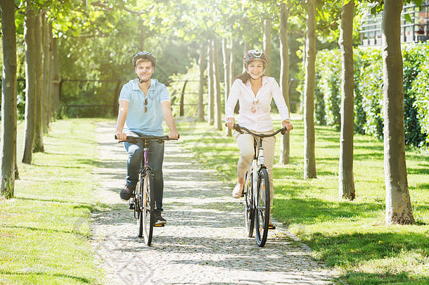 快乐年轻的夫妇骑自行车公园