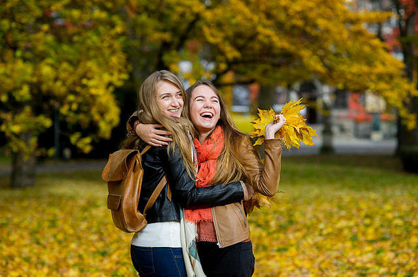 不错的女孩快乐拥抱秋天公园喜乐会议美秋天自然手女朋友花束aut
