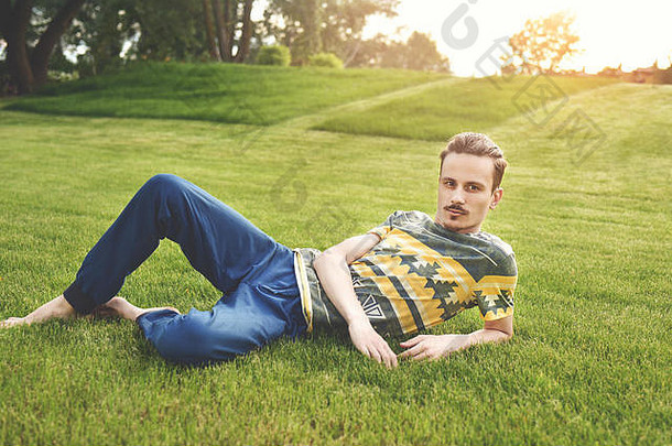 英俊的男人。草休息公园