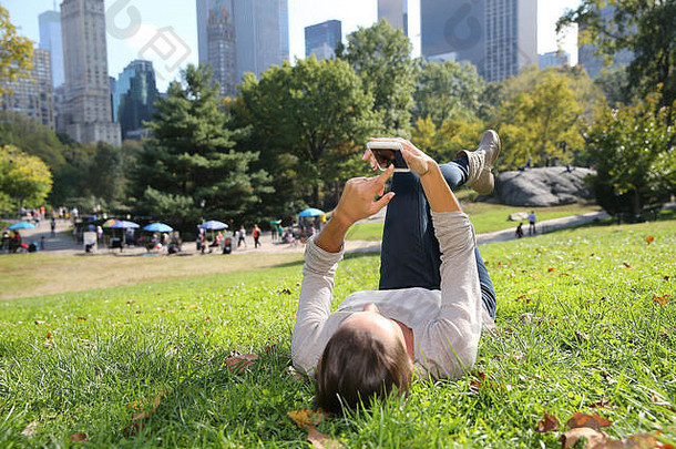 年轻的女人中央公园智能手机