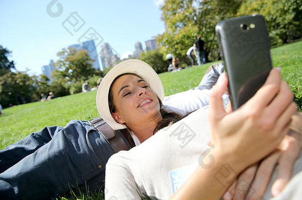 女人放松中央公园智能手机